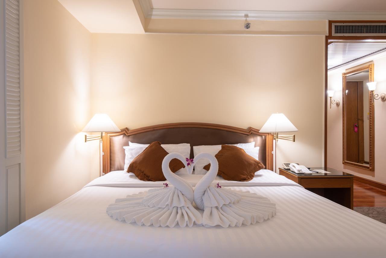 Montien Riverside Hotel Bangkok Extérieur photo A bed with a towel swan